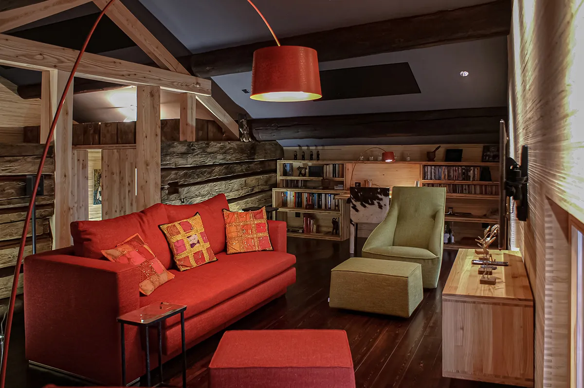 Wohnzimmer mit rotem Sofa im alpinen Stil, Ca Vegia in Graubünden