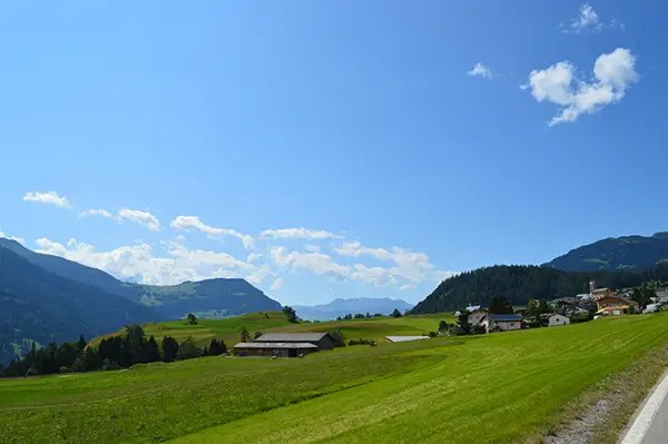 Sommeransicht des Quartier La Pala mit grünen Wiesen und Bergen